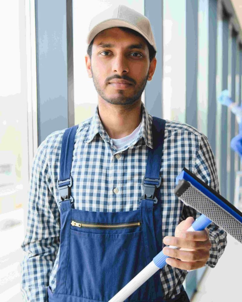 male-janitor-cleaning-window-in-office-2023-11-27-05-07-47-utc